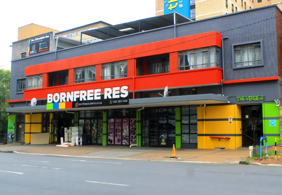 Student Residence painted in bright colours with yellow, green, gray and green accents. The skyline of Braamfontein is visible in the background.