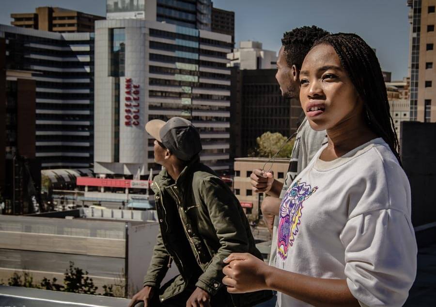 Three young black students on a rooftop in Braamfontein