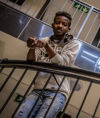 Young black student leaning over the railings in a modern student residence